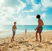 Kinder spielen am Strand, Sonne, blauer Himmel und Sand