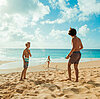 Kinder spielen am Strand, Sonne, blauer Himmel und Sand