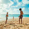 Kinder spielen am Strand, Sonne, blauer Himmel und Sand