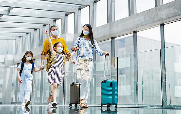 Familie mit Masken am Flughafen